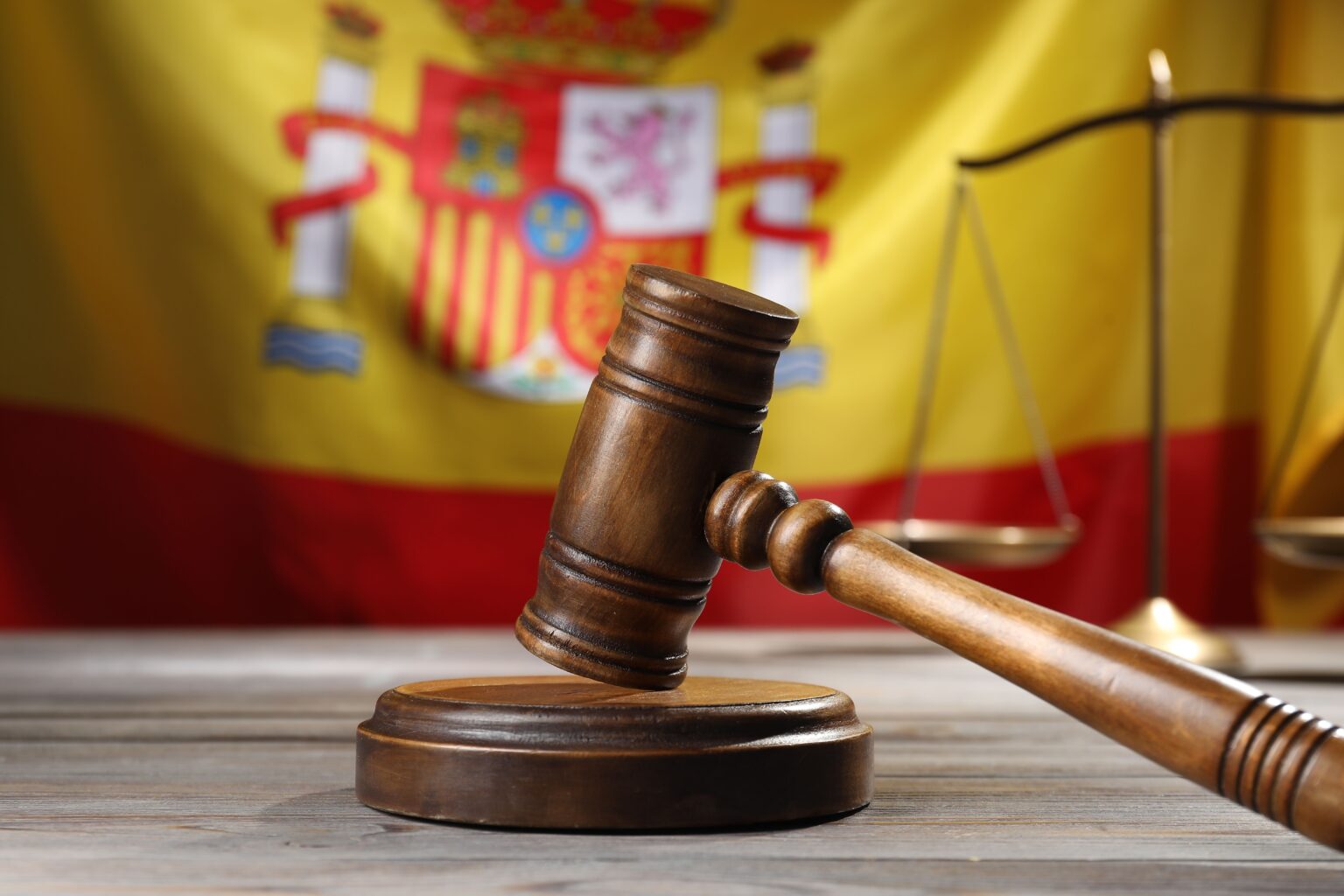 Mazo de juez y balanza de la justicia sobre mesa de madera